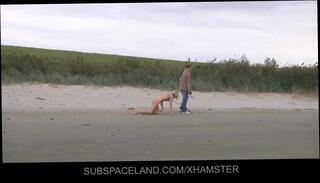 Watch the video about Slim blonde slave leashed and whipped on the beach