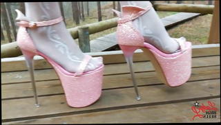 Watch the video about Lady L walking in towering pink extreme high heels.